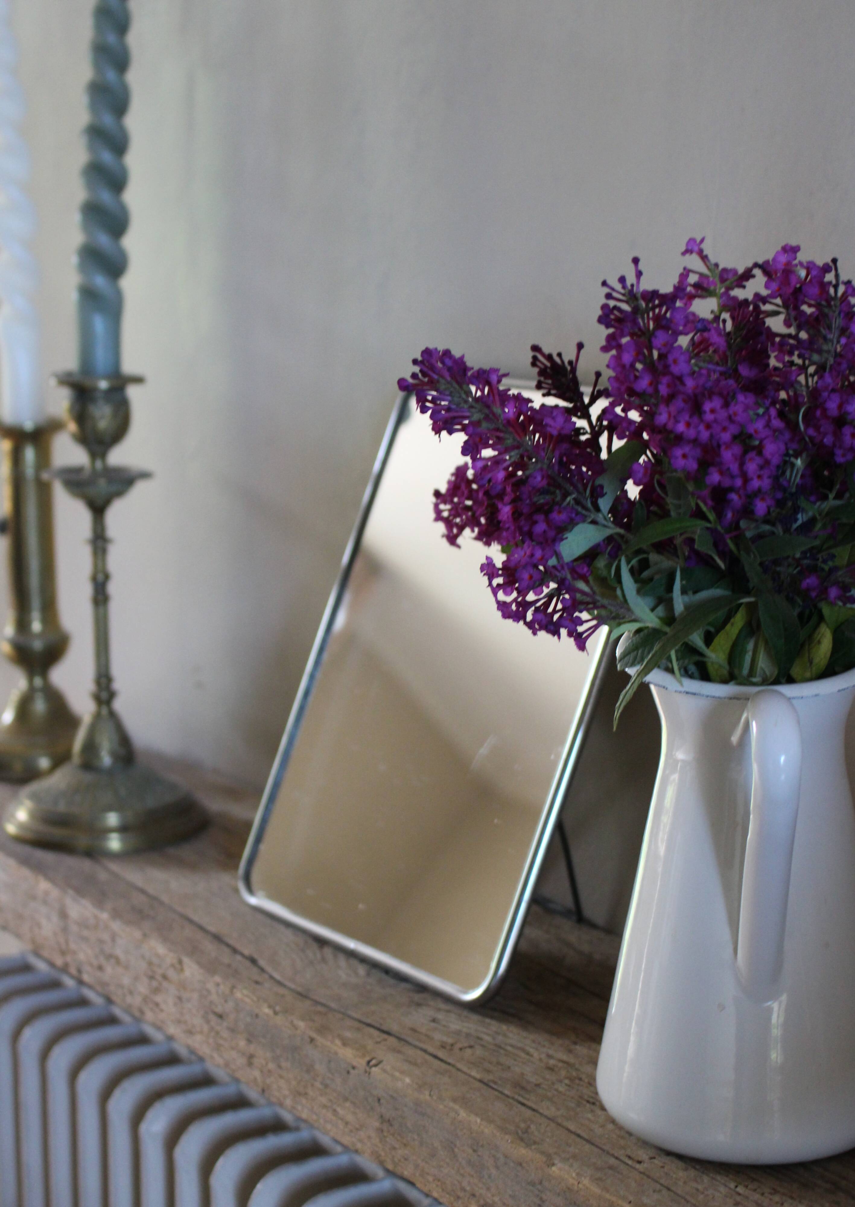 Simple rectangular barber mirror with a stand.