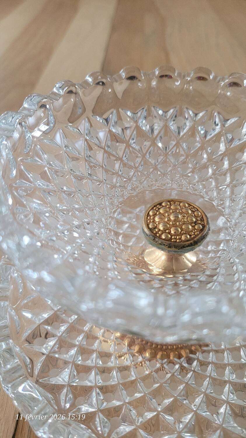Two-tier display stand in cut glass mounted on a gold metal base.