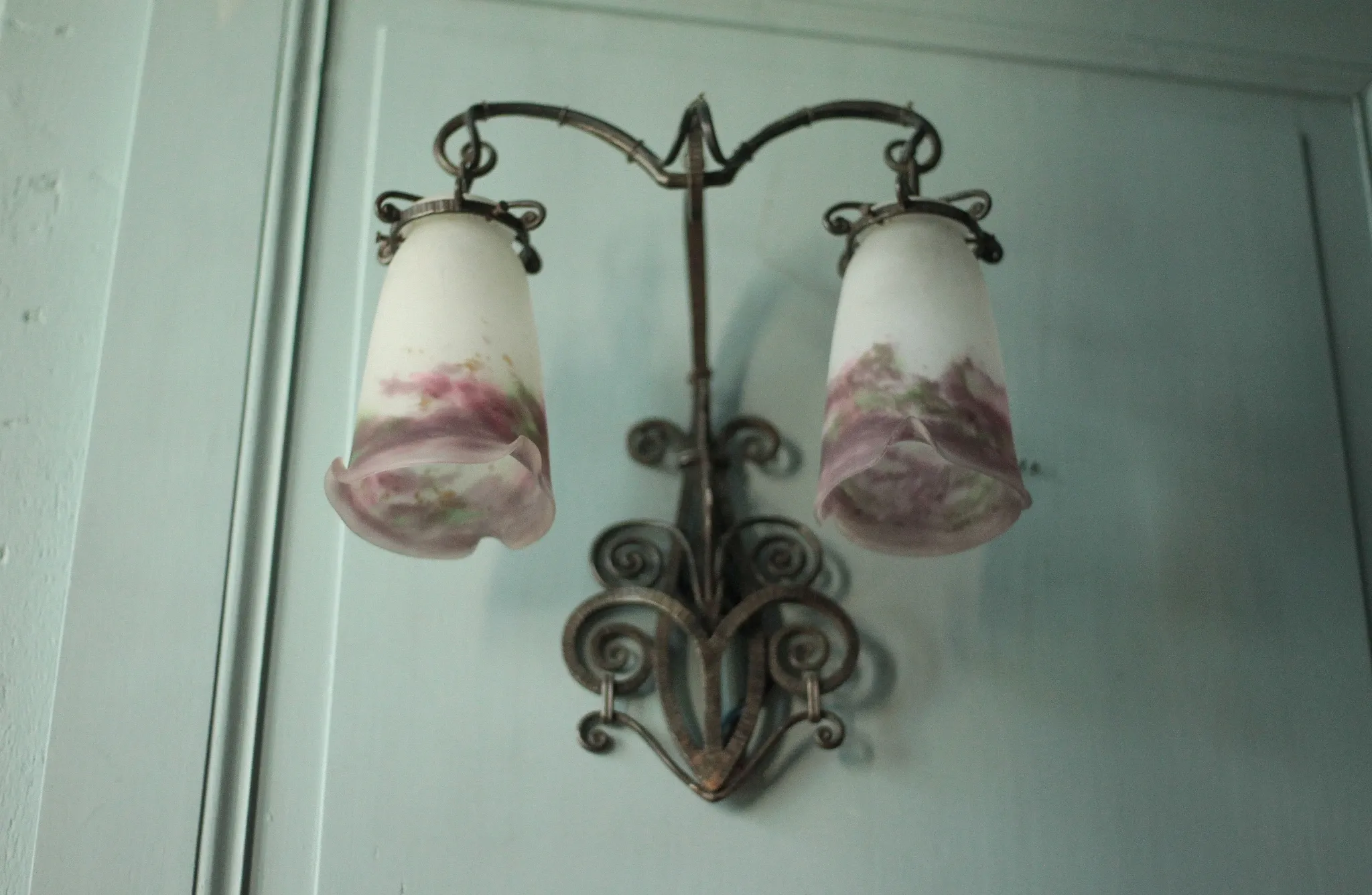 Wall lamp in wrought iron with a pink tulip glass globe by Muller glassworks.