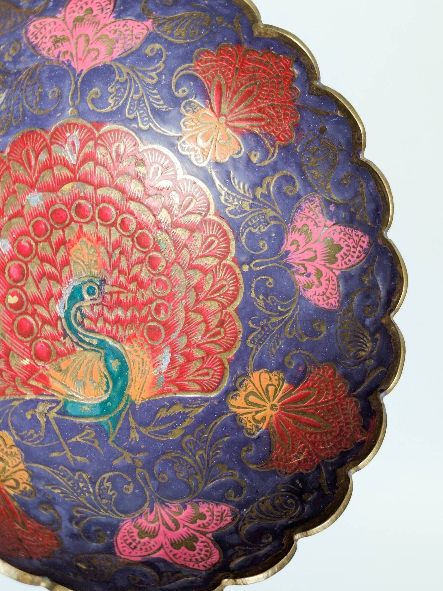 Vintage brass bowl with peacock motif, painted enamel, scalloped edge on a pedestal.