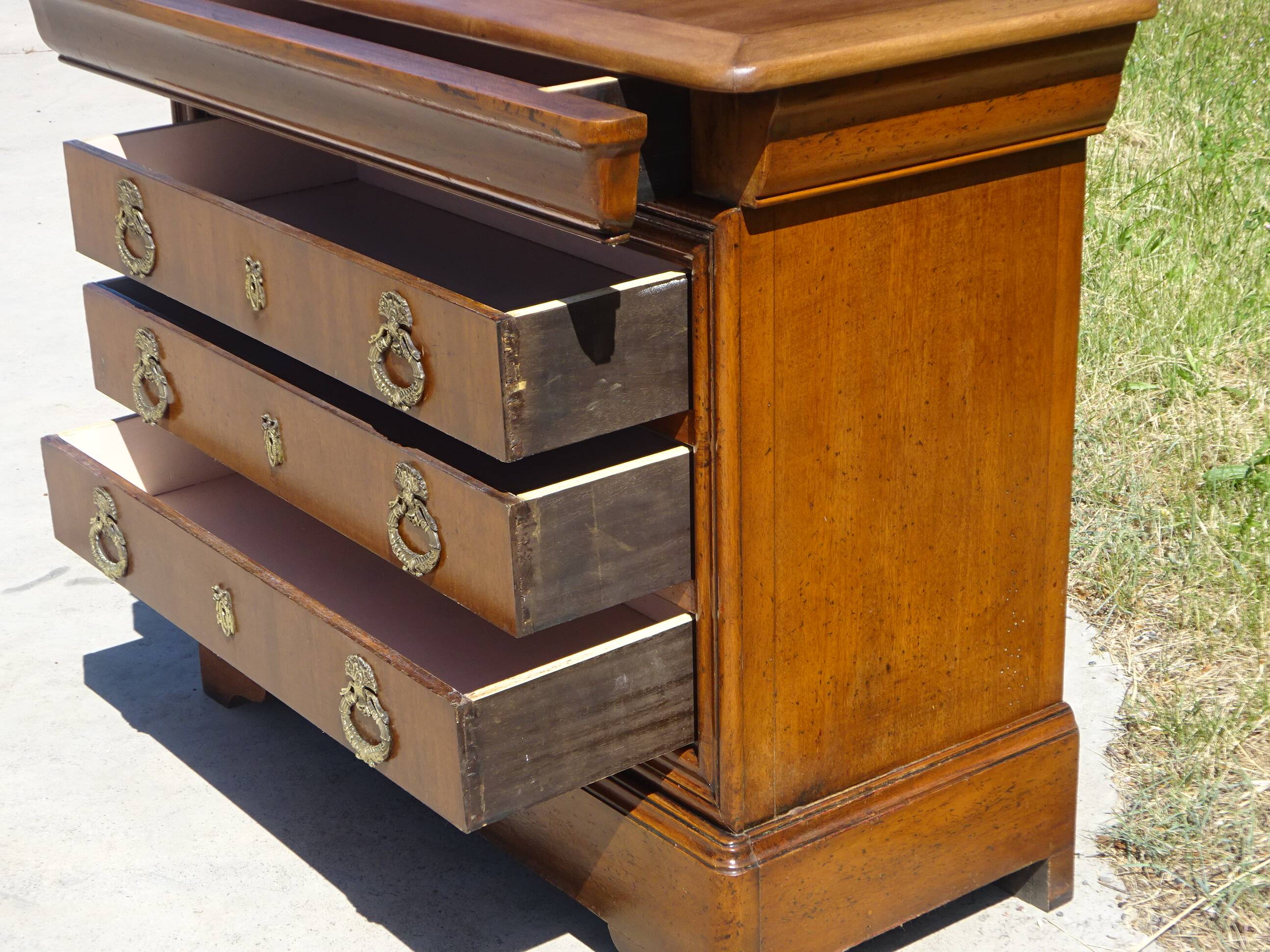 Chest of drawers with decorated handles in the Louis XVI style.