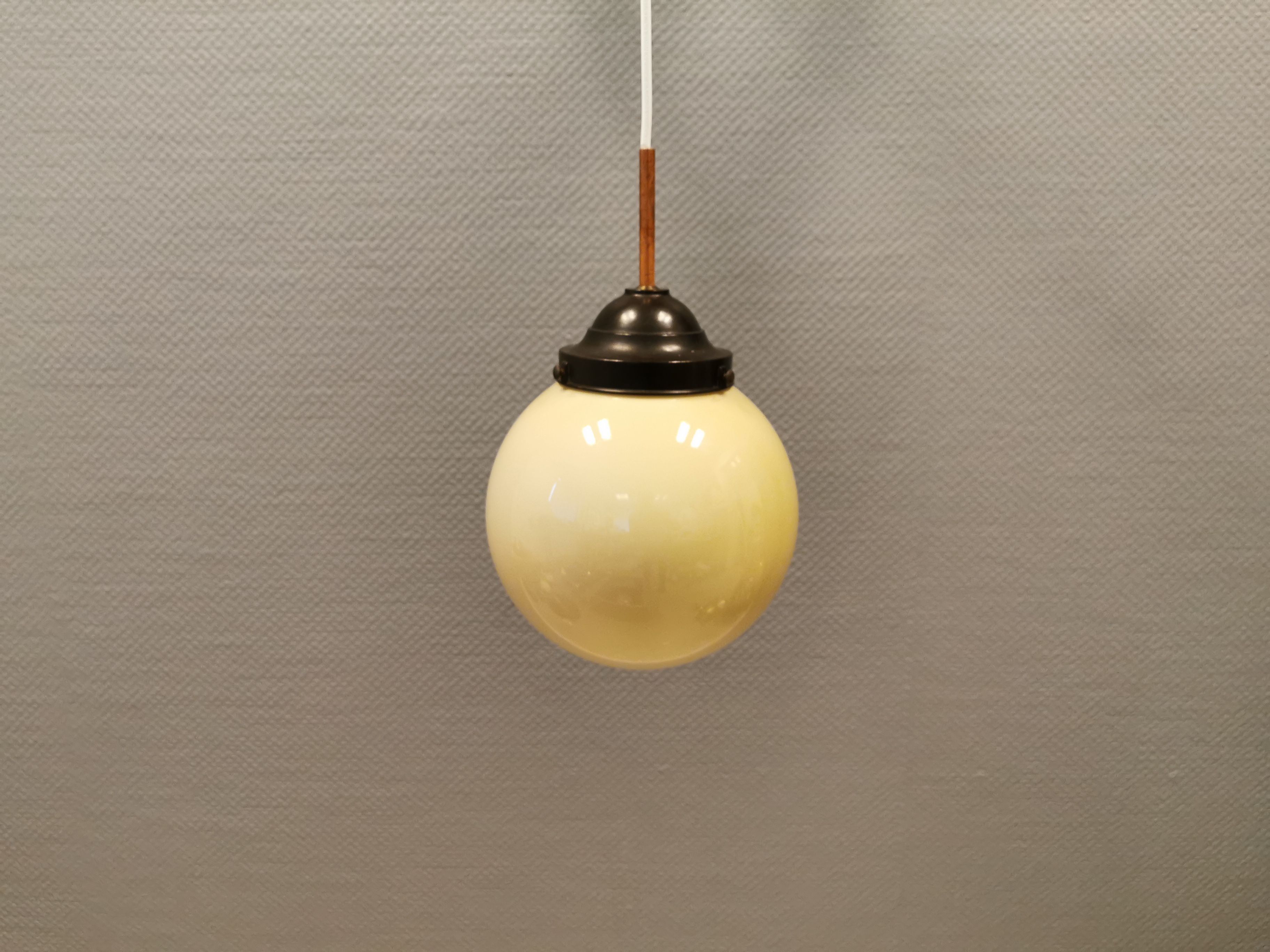 Small Art Deco hanging lamp in cream coloured glass and bakelite top.