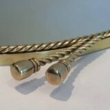 Oval brass mirror surrounded by a cord.