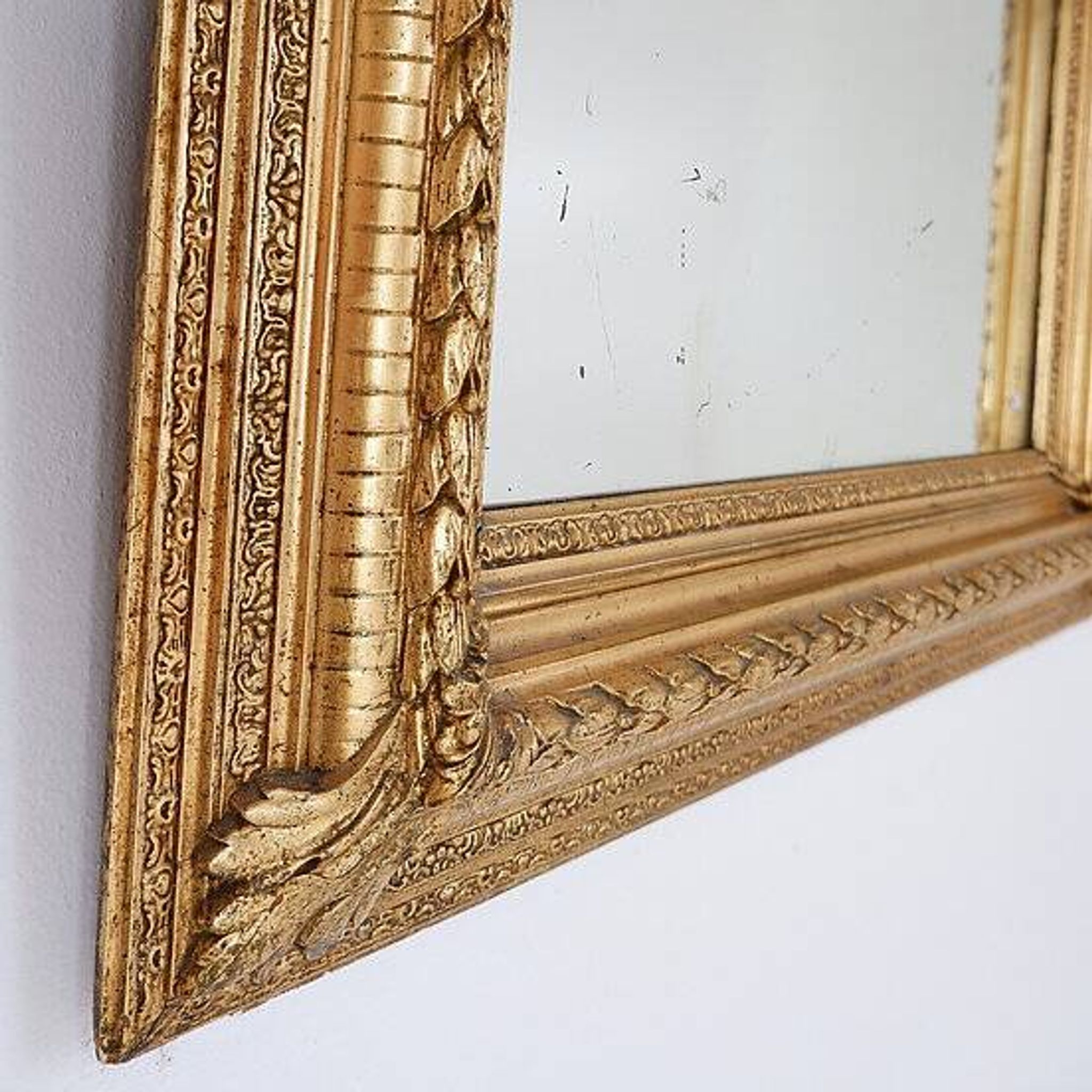 Large gilded wood and stucco mirror with foliage