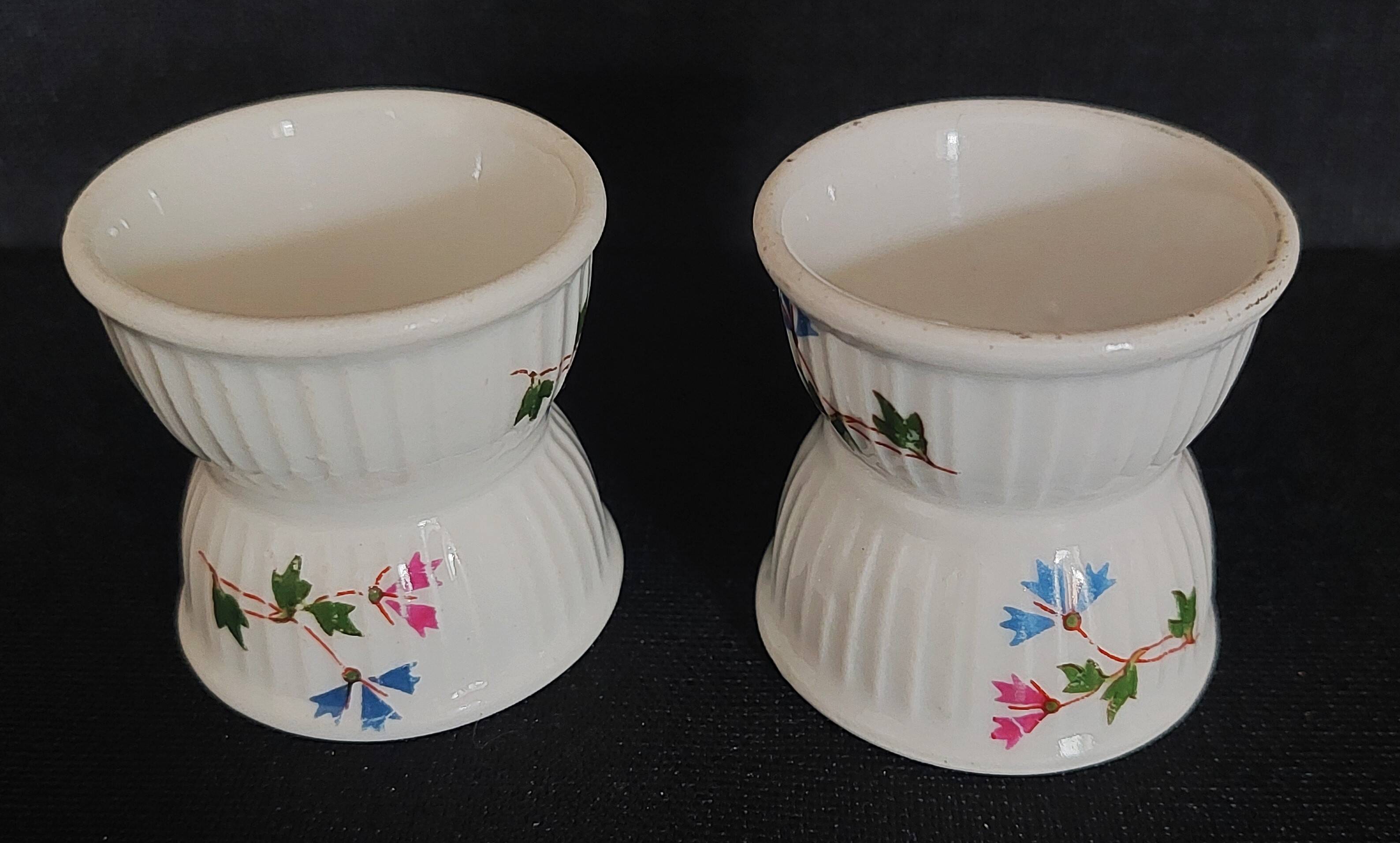 Pair of porcelain diabolo egg cups decorated with 20th century barbels