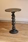 Side table with a twisted leg and a top covered with a sheet of lead.
