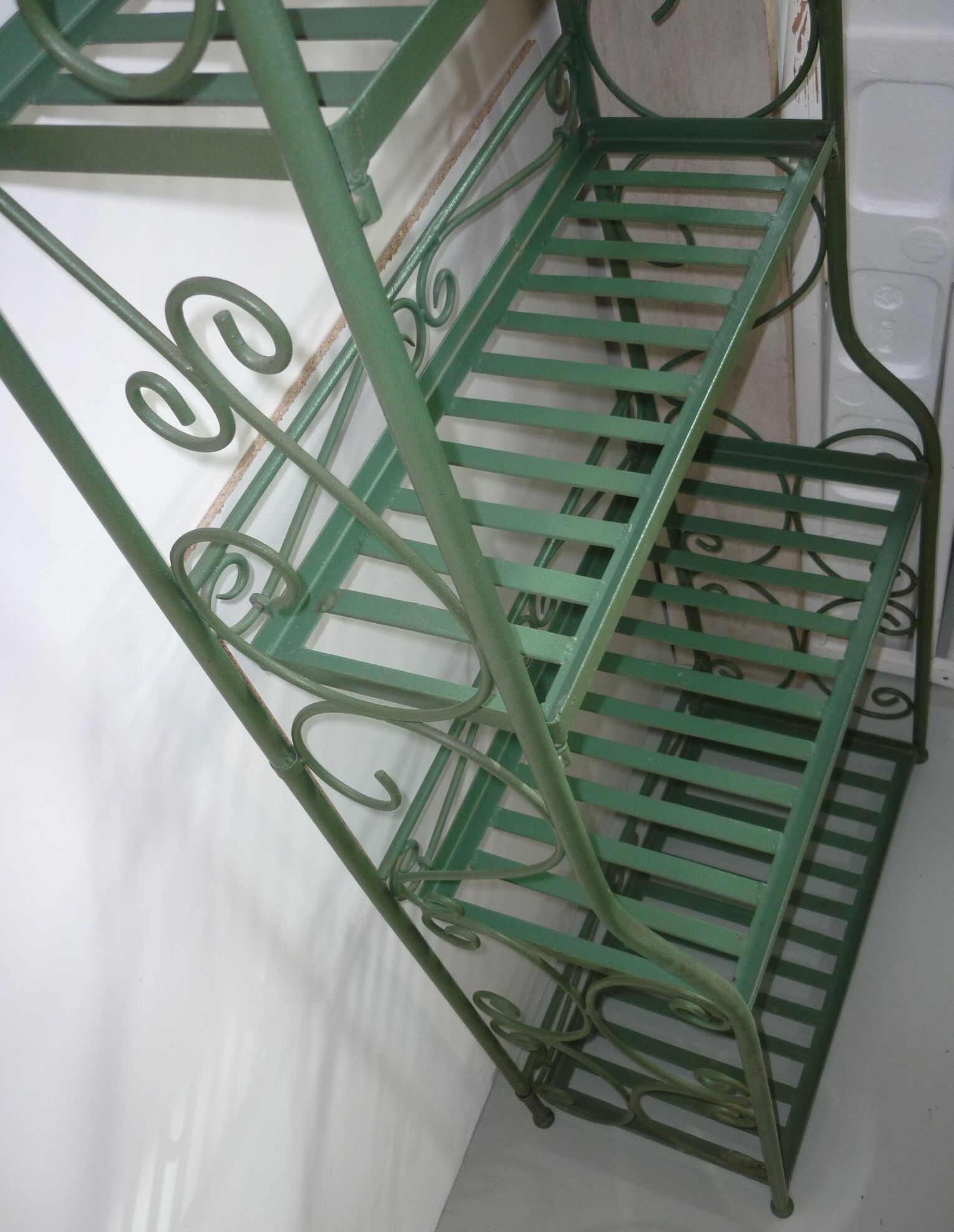 Folding green wrought iron shelf