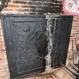huge old fireplace plate has decoration of angels, crown and fleurs-de-lis