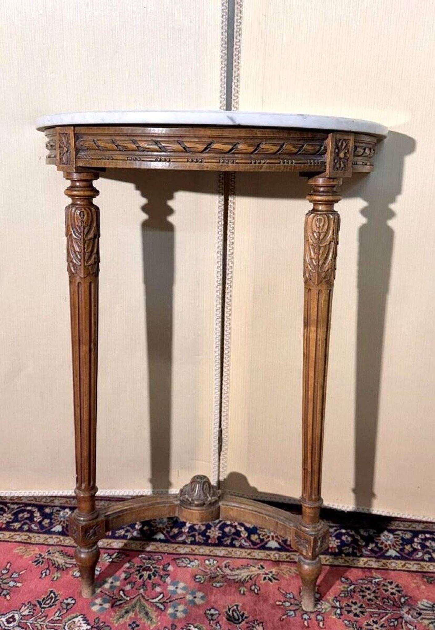 Half-moon console in Louis XVI style made of carved wood.