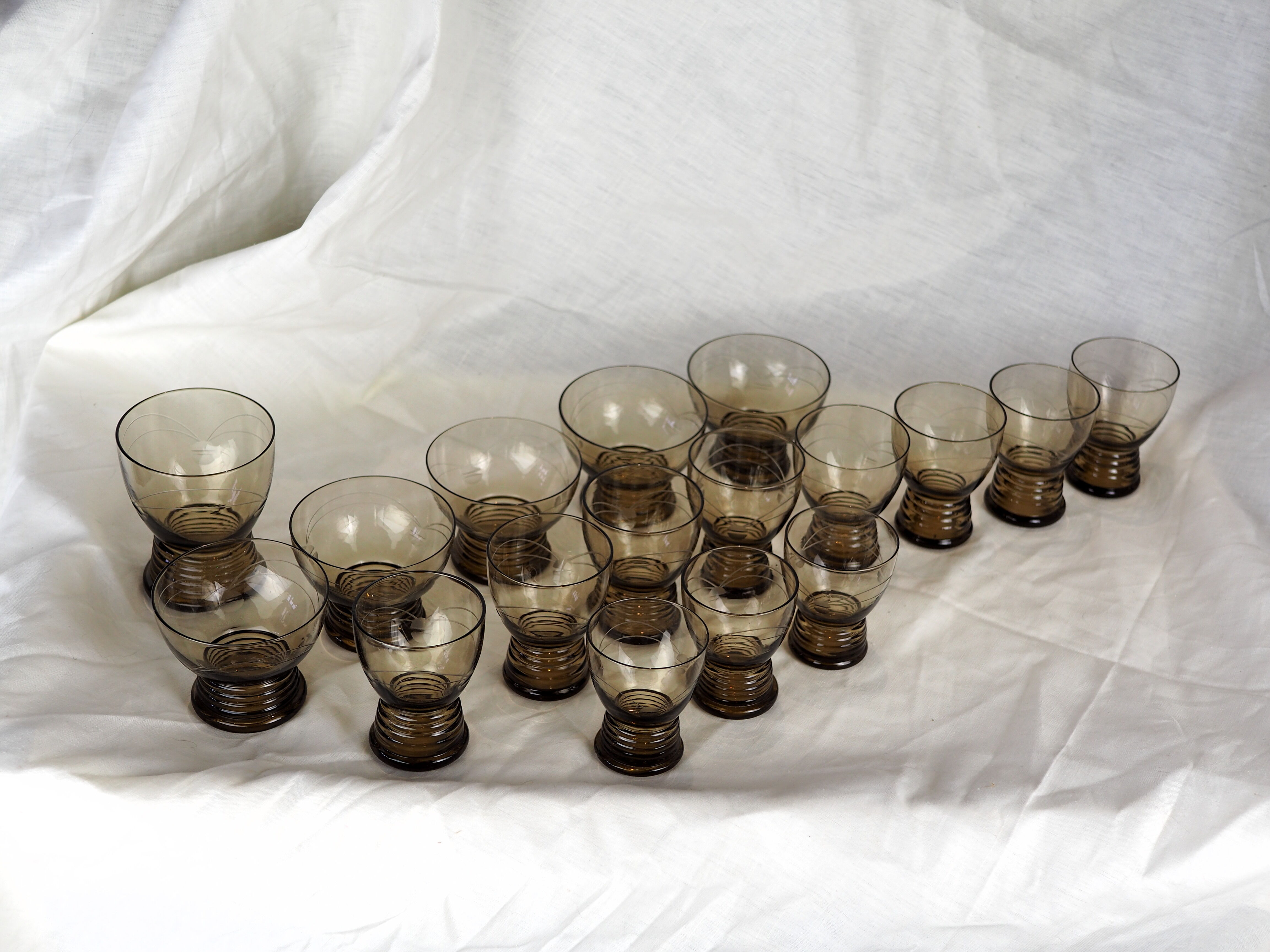 Set of 17 black smoked glasses on geometric engraving stand - 70s