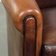 Sheepskin club armchair with deep warm colours and black piping