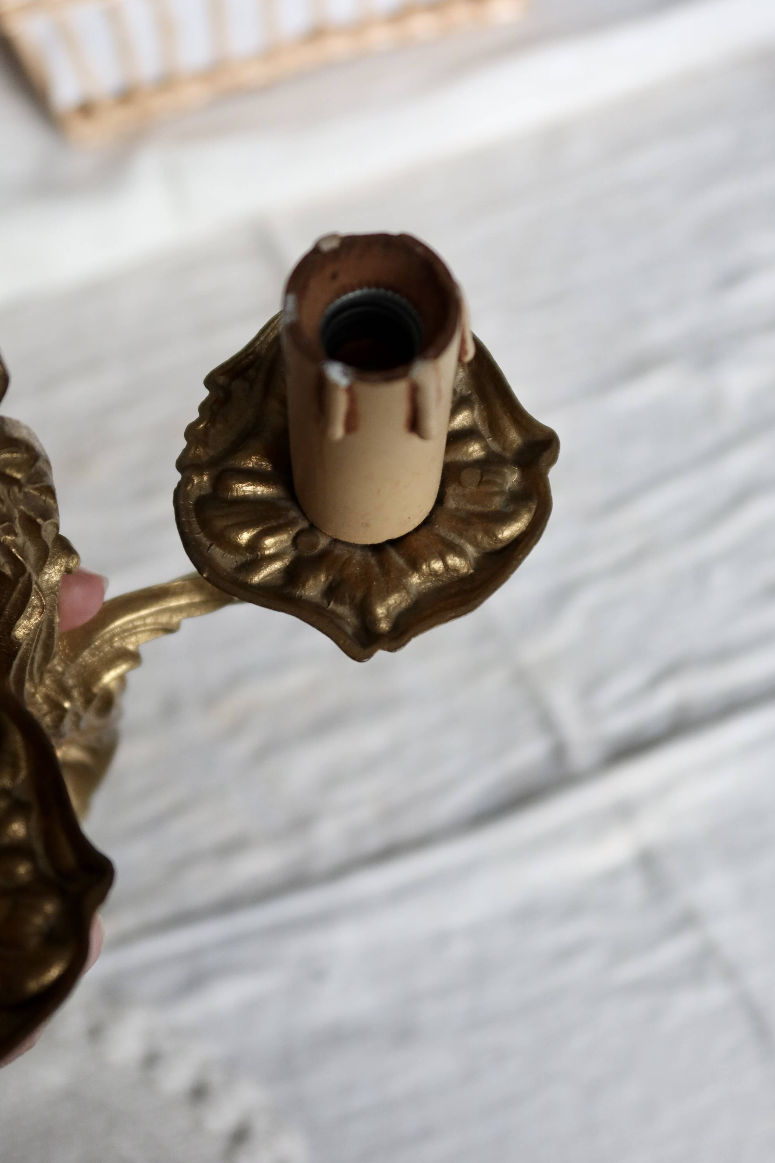 Vintage wall sconce in gold metal with two arms in classic style.