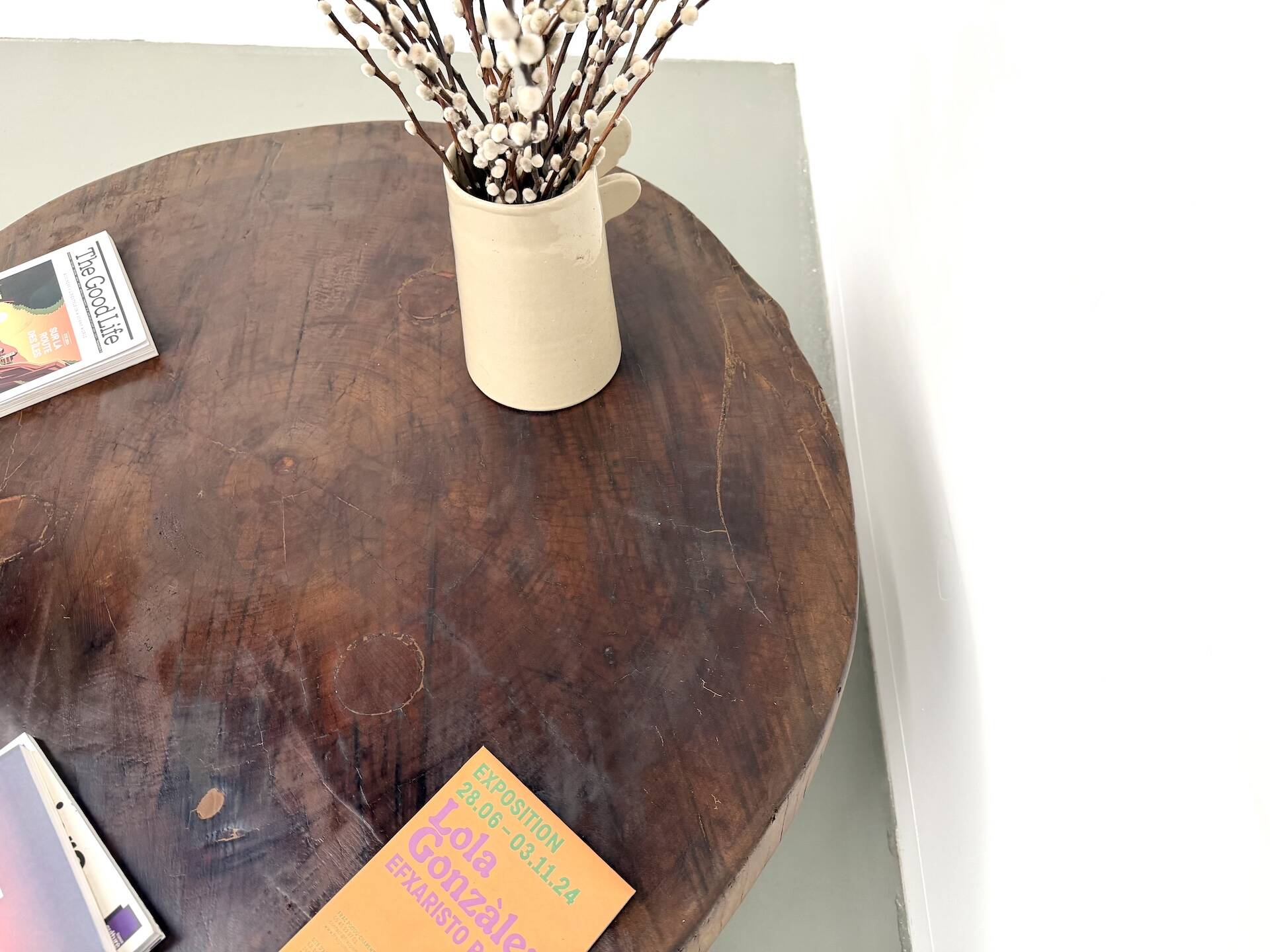 Brutalist coffee table in solid teak, monolithic slab, tripod base.