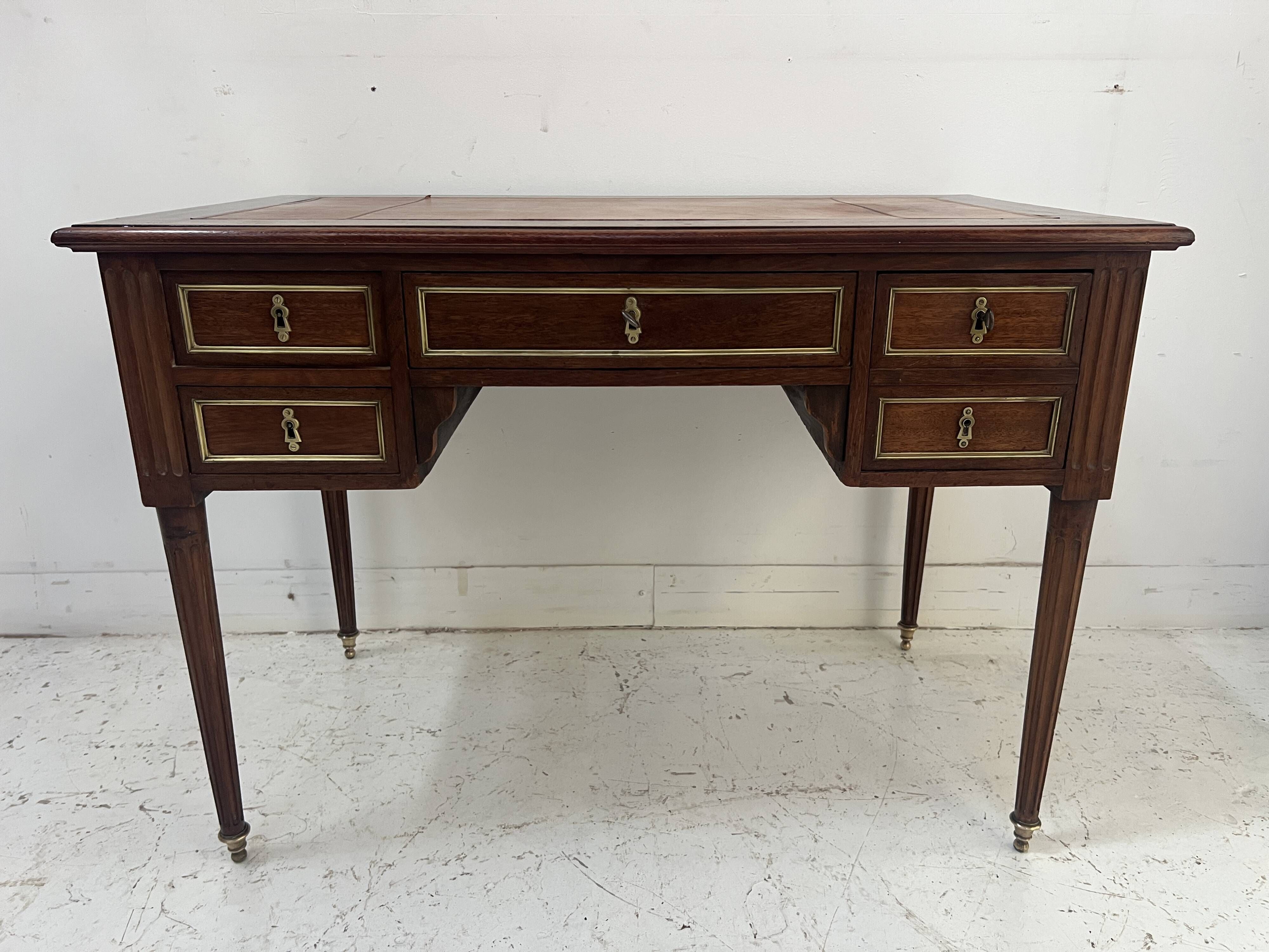 Louis XVI style desk in mahogany and mahogany veneer, 20th century.