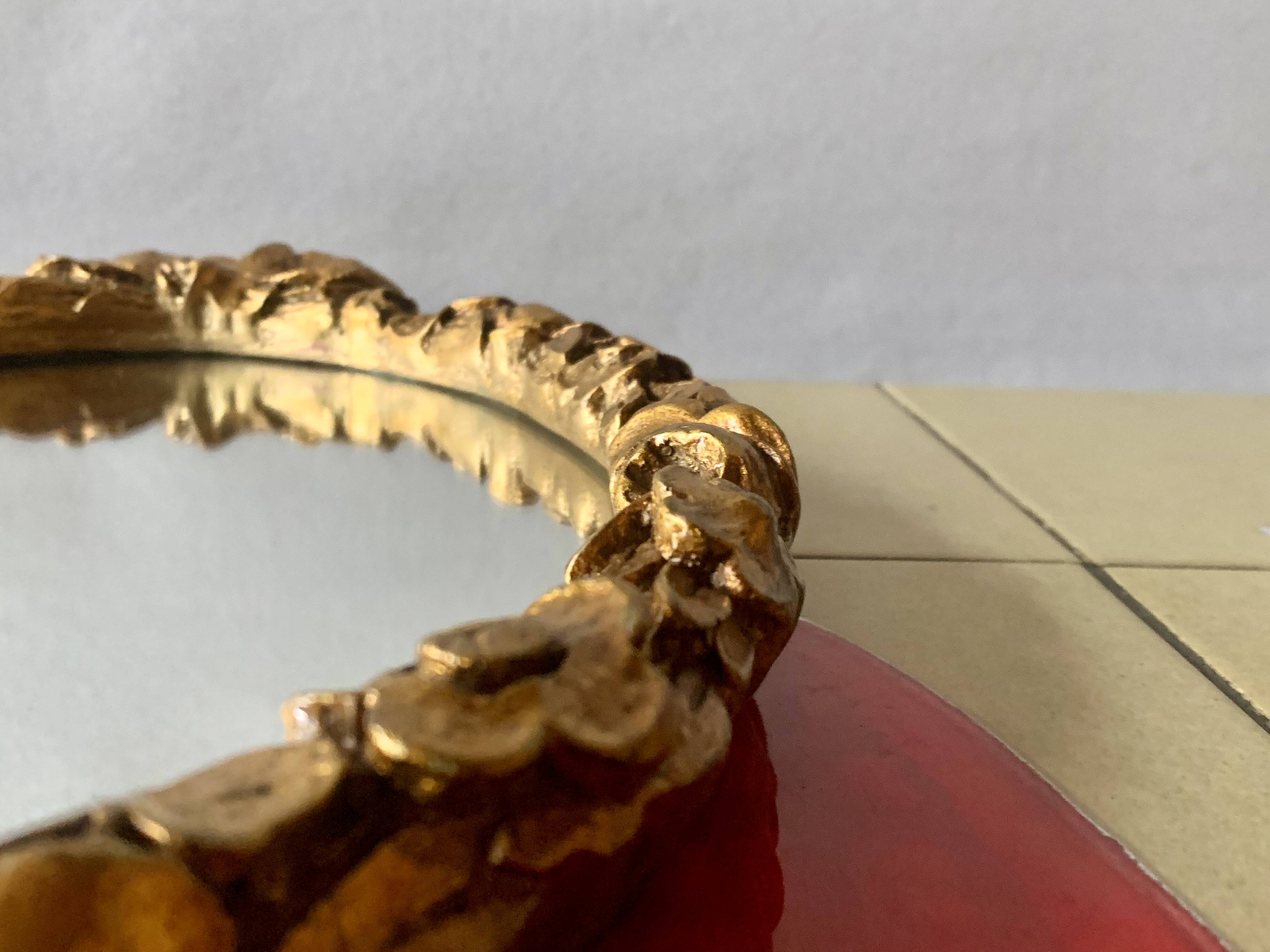 Small vintage oval wall mirror in varnished gold resin