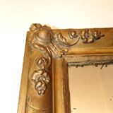 Rectangular mirror in gilded wood with relief decoration of flowers.