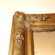Miroir rectangulaire en bois doré à décor en relief de fleurs.