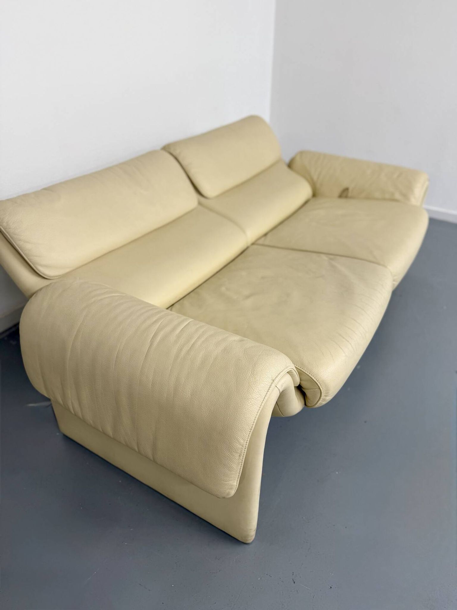 Two-seater designer sofa De Sede DS-2011 in cream leather with adjustable backrest.