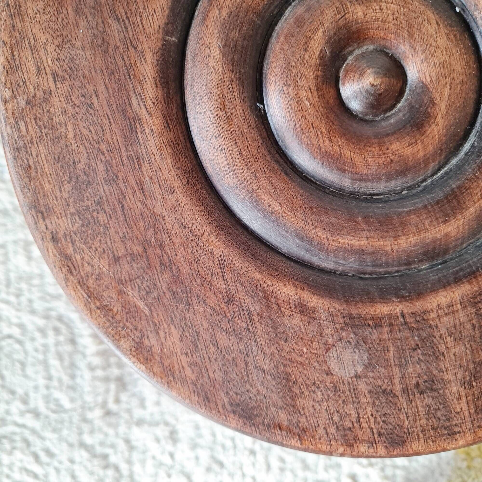Small brutalist tripod stool made of turned wood.