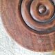 Small brutalist tripod stool made of turned wood.