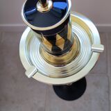 Vintage floor ashtray with a gold and black metal cigarette dispenser.