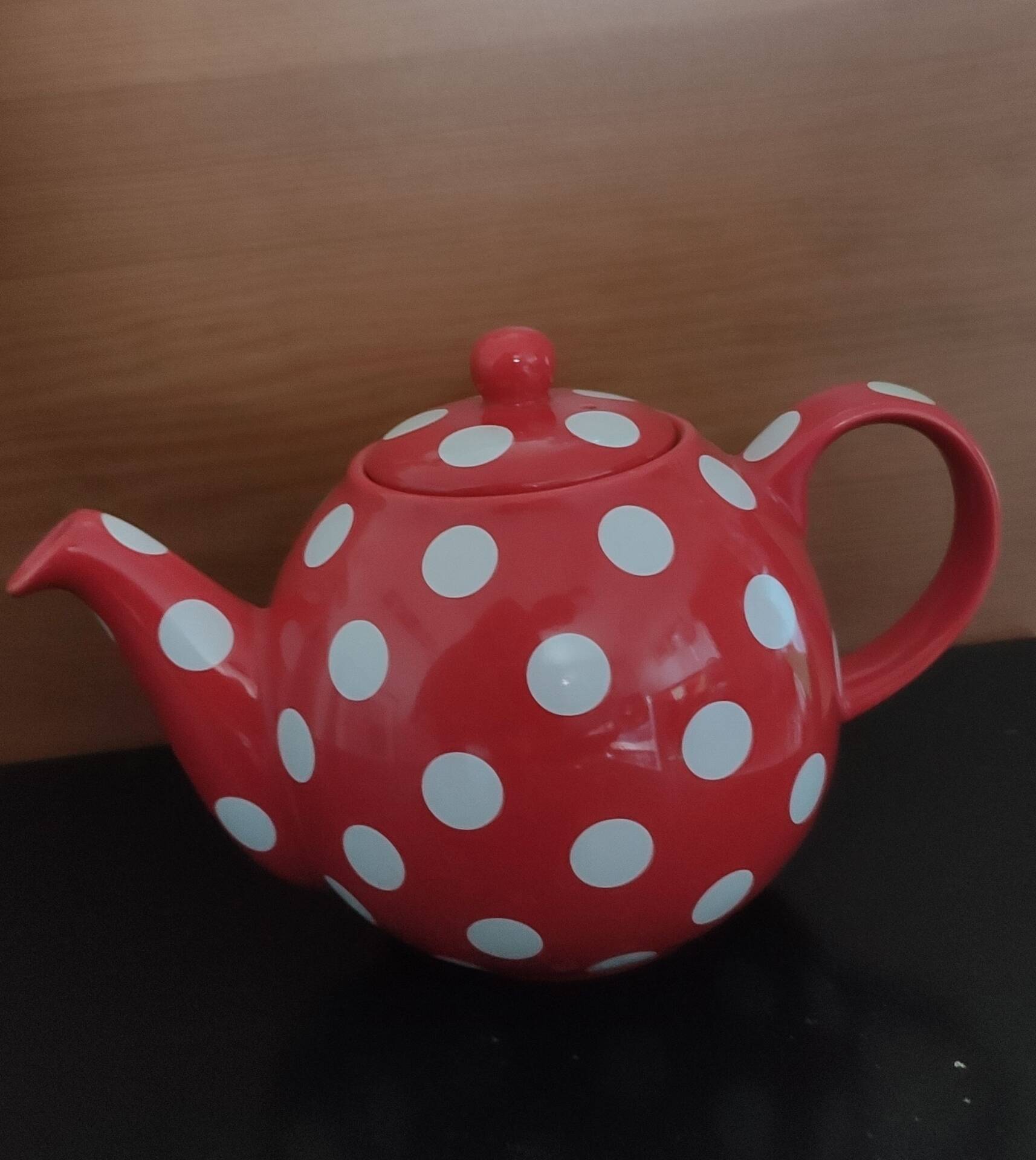 Pretty round English teapot with red polka dots.