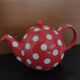Pretty round English teapot with red polka dots.