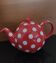 Pretty round English teapot with red polka dots.