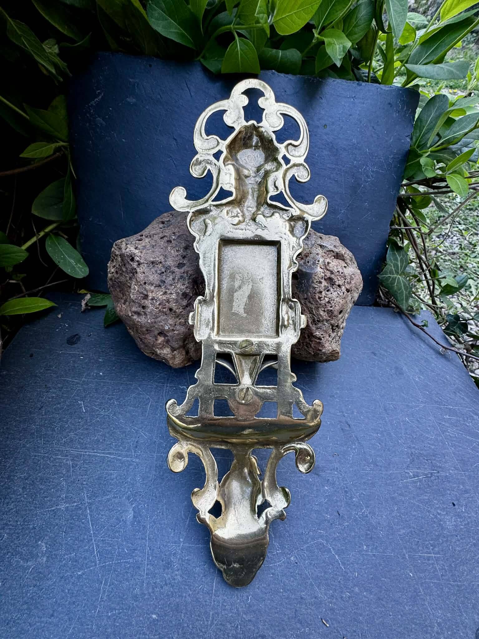 Brass magazine rack with baroque mask, wall-mounted match holder.