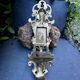 Brass magazine rack with baroque mask, wall-mounted match holder.
