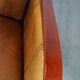 Luxurious cowhide Art Deco design armchair with wooden armrests and cognac-colored leather