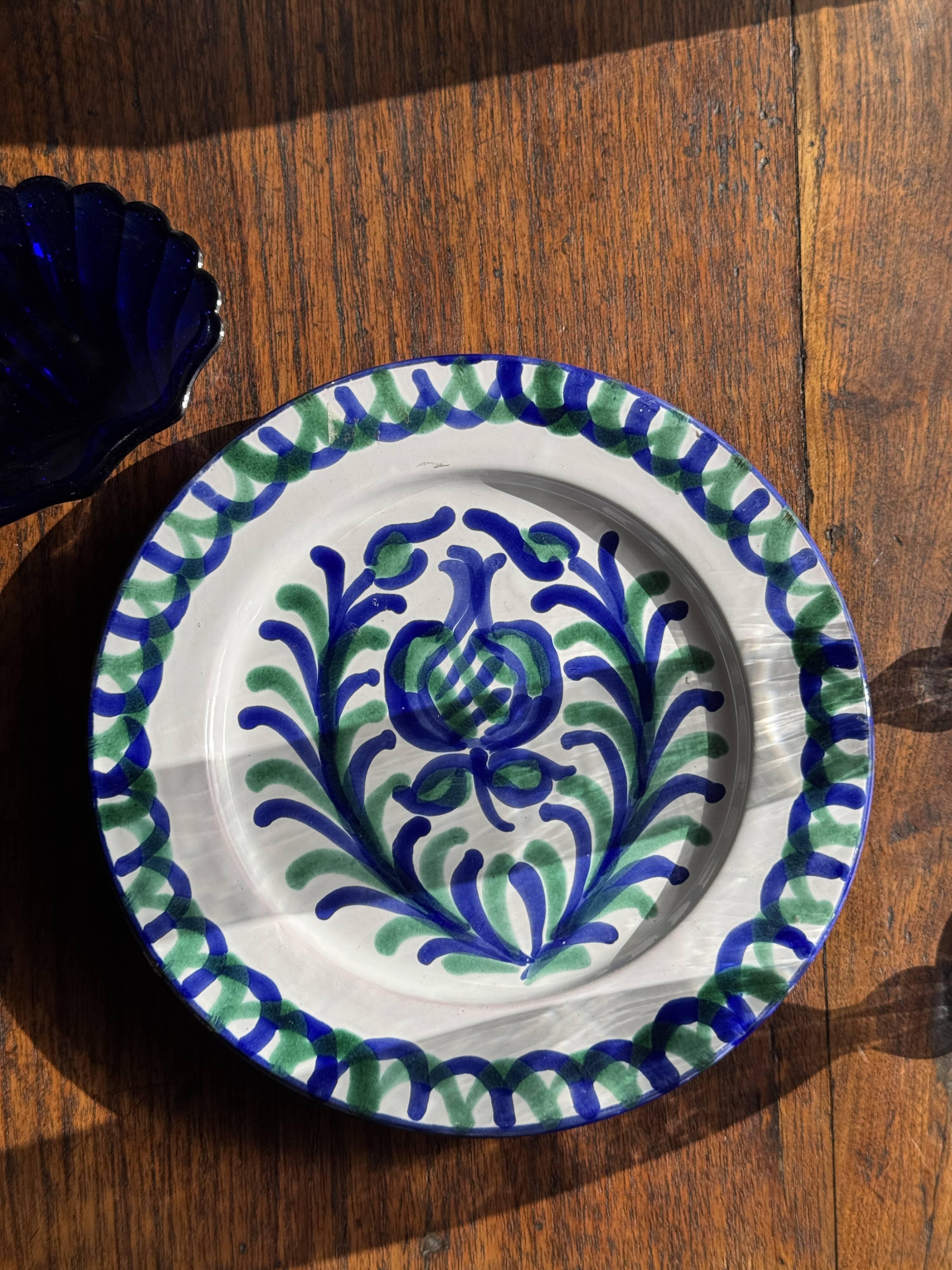 Artesania Alvarez Spanish plate in terracotta with blue plant motif.