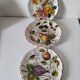 Set of three earthenware plates from Bassano, hand-painted with fruit and flower designs.