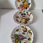 Set of three earthenware plates from Bassano, hand-painted with fruit and flower designs.
