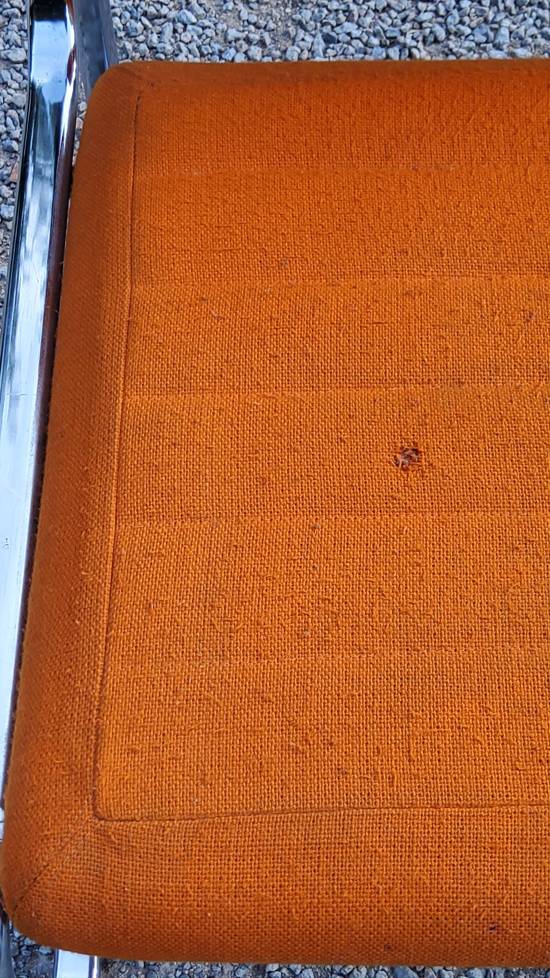 Pair of designer armchairs in orange fabrics and chrome tubes from the 70s