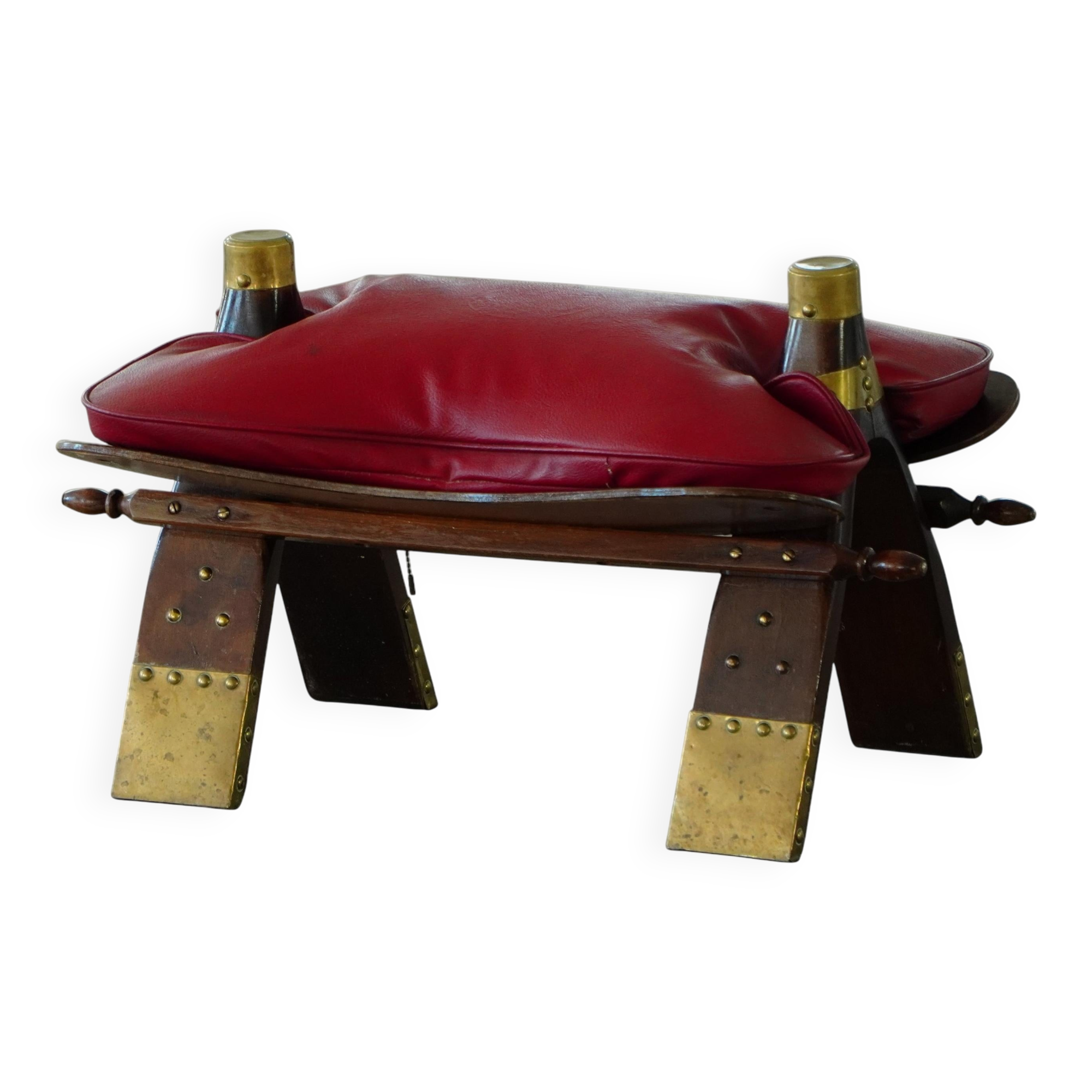 Moroccan stool in the shape of a camel saddle, stained wood, brass and leather, North Africa, 1980.