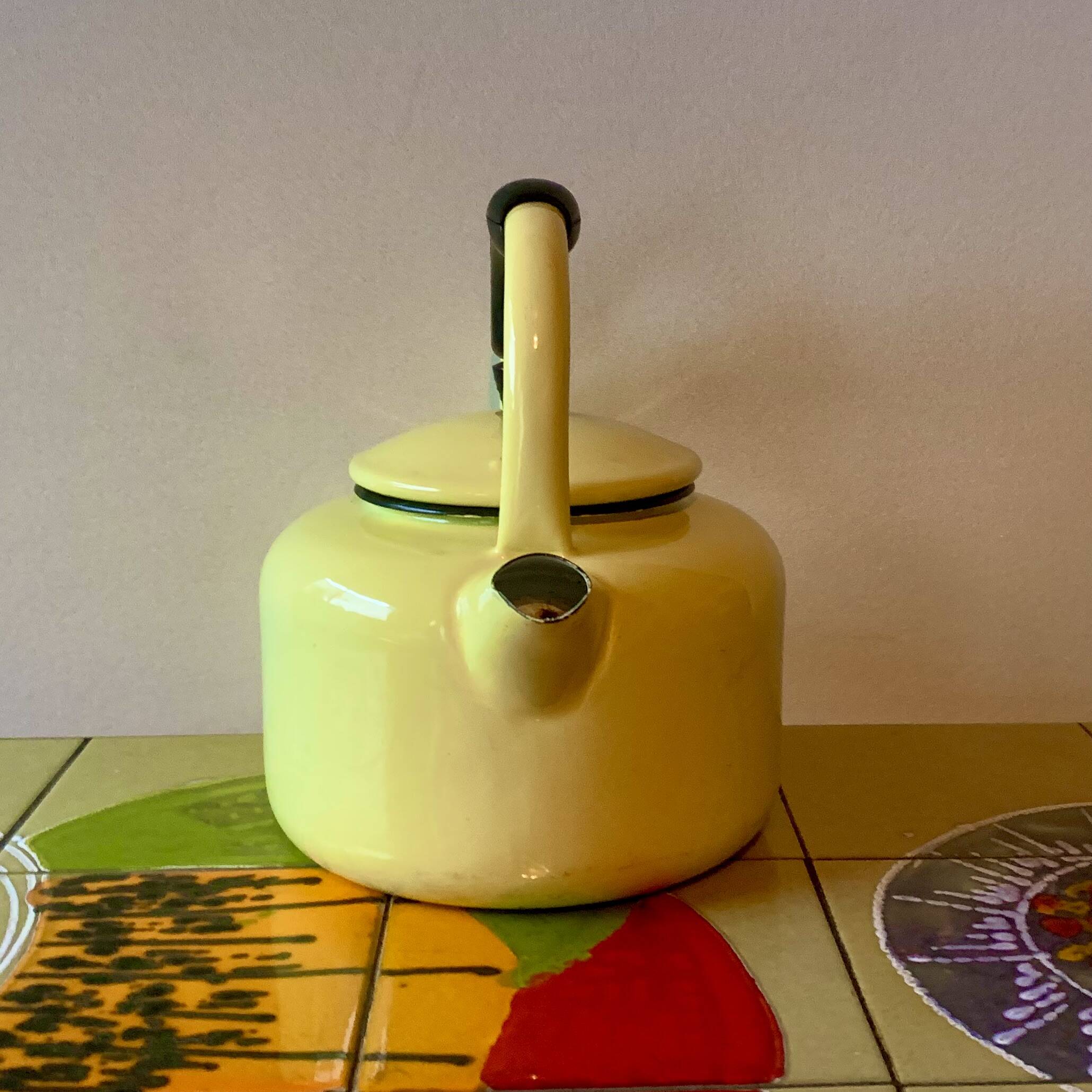 Old kettle in yellow enamelled sheet metal and Bakelite