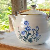 Flowery stoneware teapot with rattan handle.