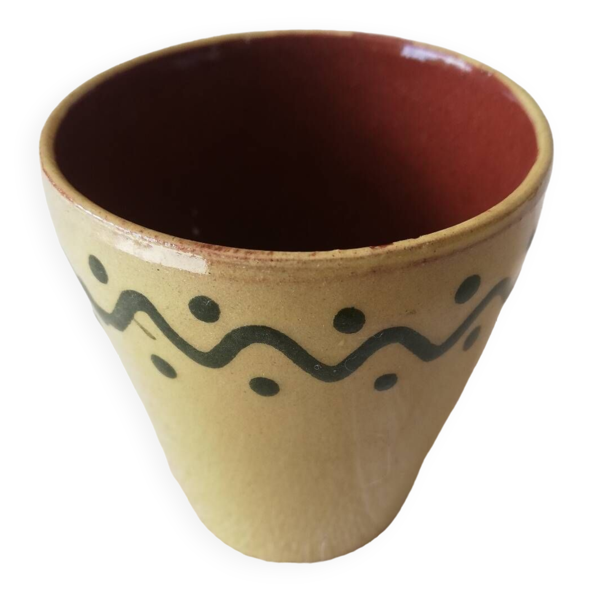 Mustard-colored ceramic cup or glass with green decor