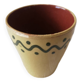 Mustard-colored ceramic cup or glass with green decor