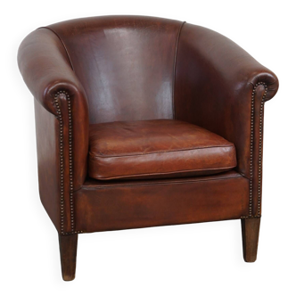 Comfortable spacious sheepskin leather club armchair with a loose seat cushion