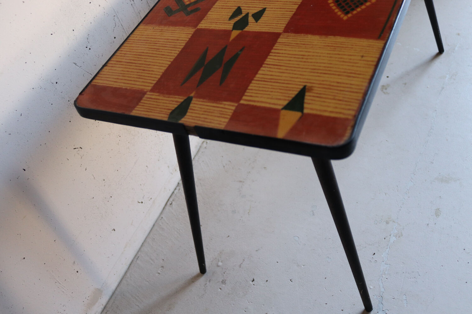 Vintage coffee table in laminate with geometric design, with tapered legs.