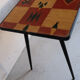Vintage coffee table in laminate with geometric design, with tapered legs.