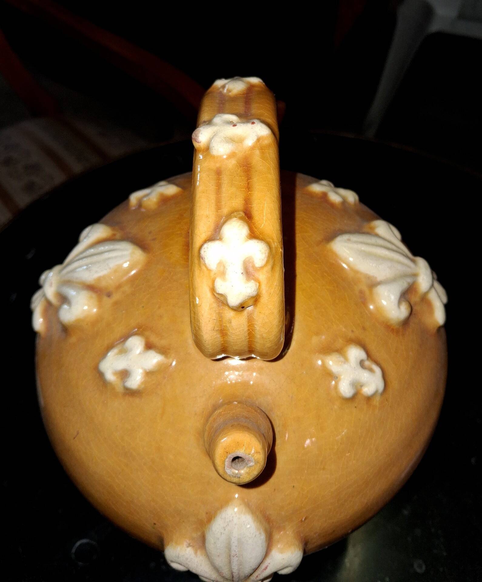 Glazed terracotta gargoyle decorated with fleur-de-lis.