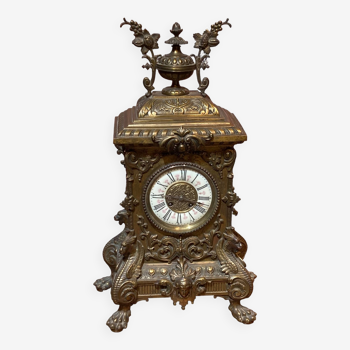 Brass clock, dragon and vine motifs.