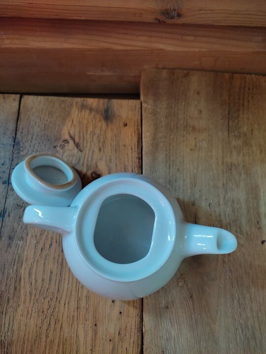 Tea pitcher teapot in old vintage white porcelain