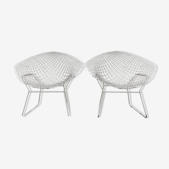 Paire de fauteuils en métal grillagé patiné blanc.