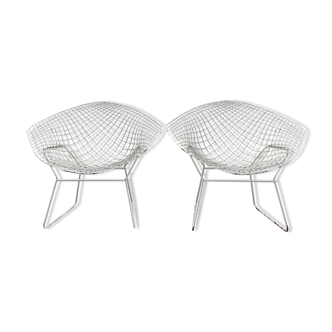 Paire de fauteuils en métal grillagé patiné blanc.