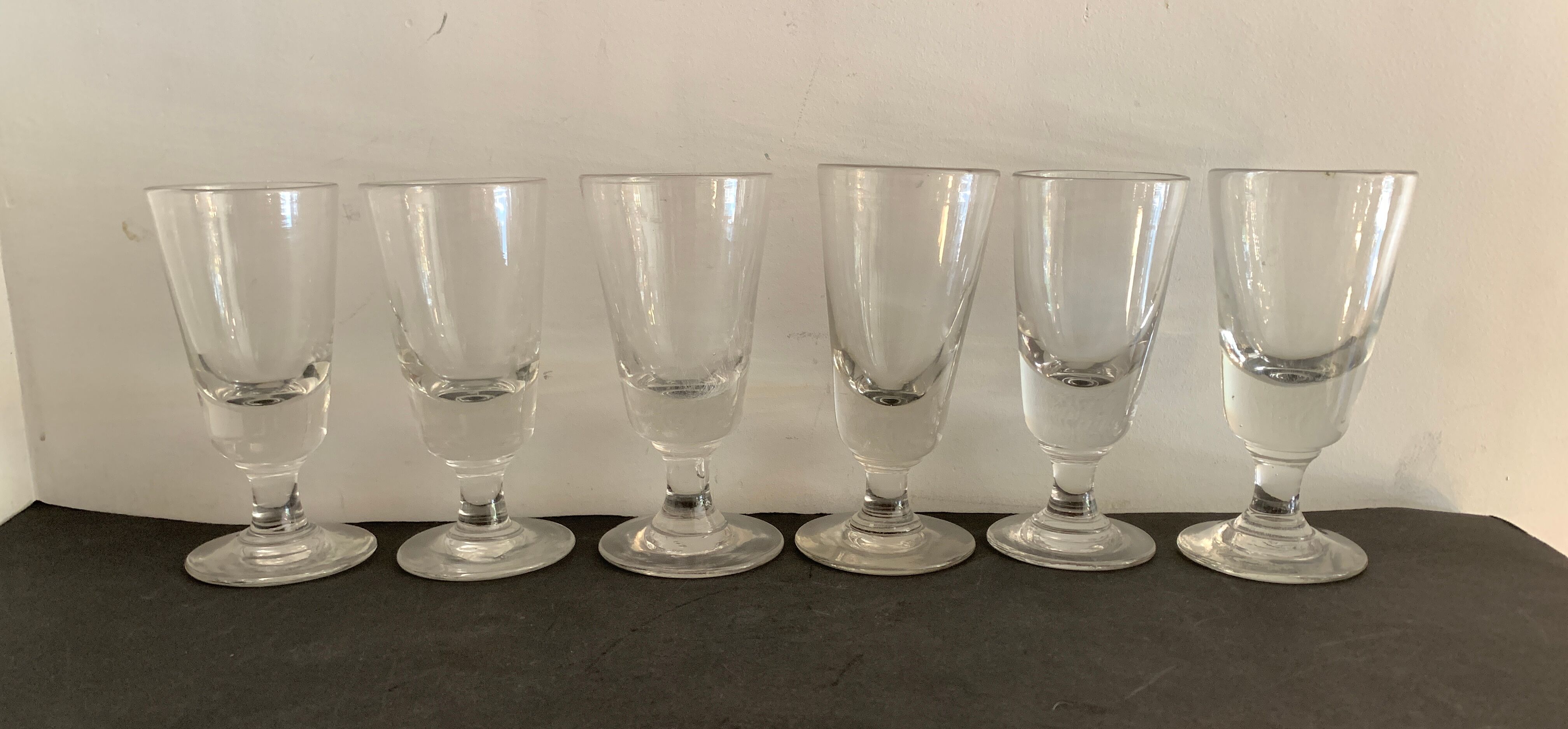 12 old glasses on foot at bistro or absinthe