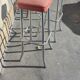 Pair of aluminum bar stools with orange and black seats